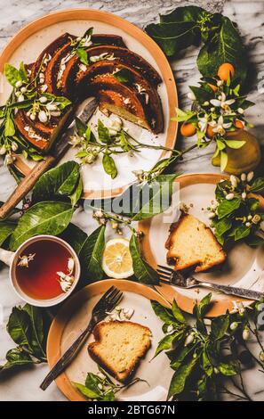 Hausgemachte Zitronenkuchen, Zitrusbäume blühende Zweige und schwarzer Tee Stockfoto