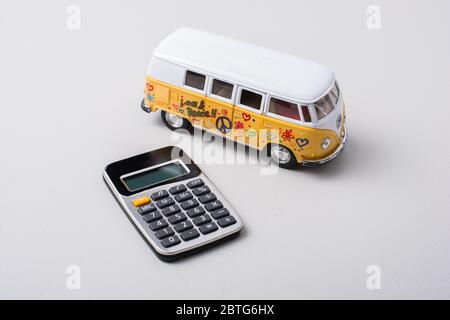 Kleiner Modellwagen und Rechner auf weißem Hintergrund platziert Stockfoto