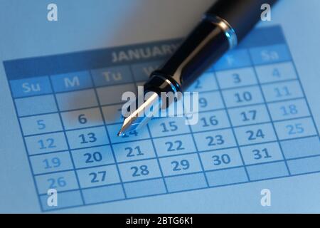 Füllfederhalter auf Kalender mit blauem Licht Stockfoto