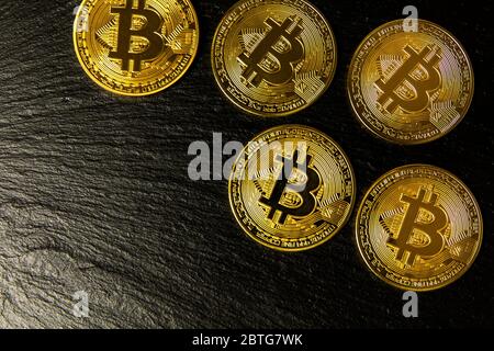 Goldene Bitcoin-Münzen. Krypto Währung goldene Münzen Bitcoin Symbol auf schwarzem Schiefer Hintergrund. Investitionen in virtuelle Währung. Stockfoto