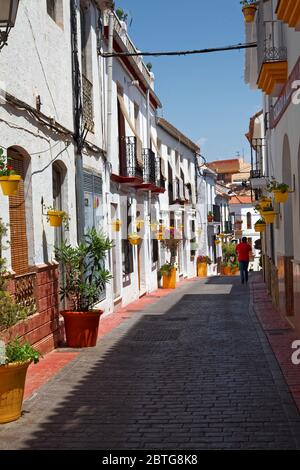 Nicht identifizierbarer Mann in rotem Hemd zu Fuß in bunten Straße, Estepona Altstadt, Malaga, Costa del Sol, Spanien Stockfoto