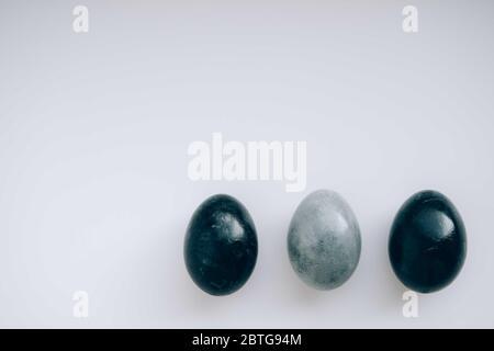 Minimalistisches monochromatisches, trendiges Easter-Flatlay in Schwarz und Grau. Natürliches Farbkonzept. Umweltfreundliches Design. Frohe ostern Karte mit Kopierraum für Text. Stockfoto