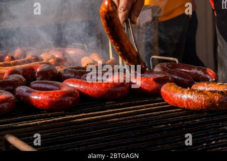 Grillen verschiedener Wurstsorten, trockenes und frisches Fleisch auf einem offenen Grill Stockfoto