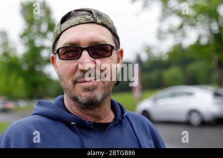 Portland, USA. Mai 2020. Gary, ein Marine-Veteran aus Gresham, hat unglückliche Erinnerungen an seinen Vater, der jung starb, aber jährlich hierher kommt, um Blumen am Grab zu legen. Der Willamette National Cemetery hat seine Gedenkfeiertage zum ersten Mal seit über fünfzig Jahren aufgrund der COVID-19 Pandemie abgesagt, aber trotz der Regenfälle kamen viele Familien, um am 25. Mai 2020 Blumen und Flaggen auf die Gräber von Verwandten in Portland, Oregon, zu legen. (Foto von John Rudoff/Sipa USA) Quelle: SIPA USA/Alamy Live News Stockfoto