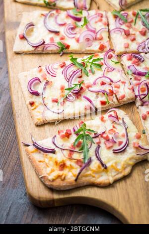 Traditionelle französische Gerichte Flammkuchen-Frischkäse, Speck und Zwiebeln. Flammkuchen aus dem Elsass. Flammenkuchen. Stockfoto