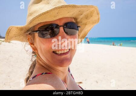 Ein Porträt einer lächelnden Frau mittleren Alters am Makalawena Beach, Kona Hawaii, USA. Stockfoto