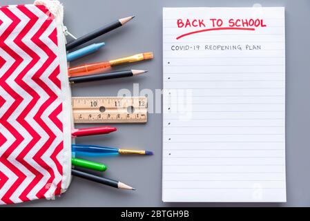Zurück zur Schule COVID-19 Schule Wiedereröffnung Plan Konzept erschossen. Flay legen Anordnung mit Schulbedarf Stockfoto