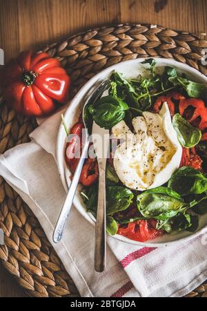 Italienischer Salat mit Buratta-Käse, Tomaten, Rucola und frischem Basilikum Stockfoto