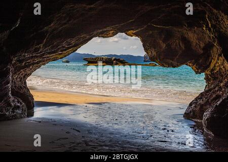 Blick aus einer kleineren Meereshöhle bei Cathedral Cove auf der Halbinsel Coromandel bei Hahei, Neuseeland an einem sonnigen Tag Stockfoto