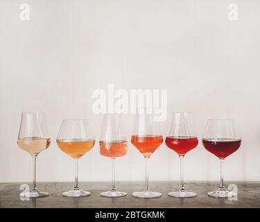 Verschiedene Schattierungen von Roséwein in Gläsern auf Betontisch Stockfoto