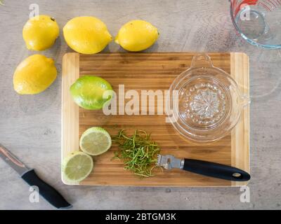 Mit einem Glas-Handentsafter und Zester Saft und Schwarte aus Zitronen und Limetten für ein Rezept zu extrahieren Stockfoto