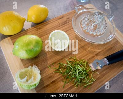 Mit einem Glas-Handentsafter und Zester Saft und Schwarte aus Zitronen und Limetten für ein Rezept zu extrahieren Stockfoto