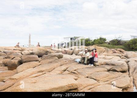 Touristenpaar an der Küste ausruhen und mit dem Fernglas suchen, in Cabo Polonio, Uruguay Stockfoto