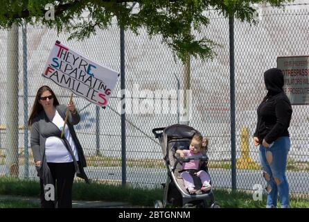 Baltimore, Maryland, USA. Mai 2020. Frau, die in der Nähe eines Kleinkindes in einem Kinderwagen und einer anderen Frau in einem Hoodie steht, trägt Schild mit der Aufschrift "Sie trennen Familien", außerhalb des historischen Fort McHenry in Baltimore, Maryland; Wo Präsident Donald Trump und First Lady Melania Trump am Memorial Day 2020 besuchen, obwohl er vom Bürgermeister von Baltimore, Bernard C. „Jack“ Young, aufgefordert wird, abzusagen, um ein schlechtes Beispiel zu vermeiden, während die Stadt unter einer Aufenthaltsordnung bleibt (mit Ausnahmen, einschließlich einiger Outdoor-Übungen). Kay Howell/Alamy Live News Stockfoto