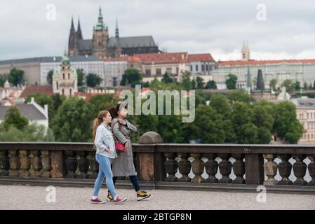 Eine Frau und eine junge Dame werden nach dem Aufzug der obligatorischen Regel, Gesichtsmasken zu tragen, auf der Karlsbrücke spazieren sehen.Pflichttragen von Schutzmasken aufgrund der Coronavirus-Pandemie, die am 19. März von der tschechischen Regierung eingeführt wurde, Wurde am 25. Mai zum Stillstand gebracht, aber Facemasken sind immer noch obligatorisch für öffentliche Verkehrsmittel und in Innenräumen, wo die Menschen nicht garantieren können, dass sie mindestens 2 Meter voneinander entfernt stehen. Stockfoto