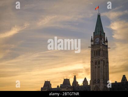 Die Sonne geht hinter dem Centre Block des kanadischen parlamentsgebäudes in Ottawa gegen einen lebhaften Abendhimmel unter. Stockfoto