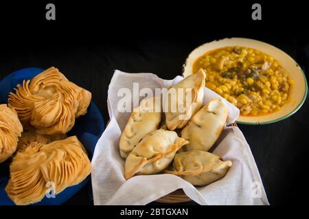 Gerichte von locro Empanadas und süßes Gebäck, traditionelle argentinische Lebensmittel, die häufig für nationale Feiertage konsumiert werden, wie die Revolution o Stockfoto