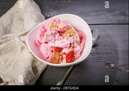 Erdbeersorbet mit Marmelade, Beeren und Puffreis in einer weißen Schüssel. Hausgemachte Köstliche Nachspeisen. Kopierbereich Stockfoto