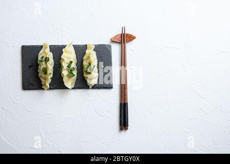 Kimchi Knödel Fleisch Knödel auf schwarzem Stein Platte über weiß texturierten Hintergrund Draufsicht Raum für Text niemand. Stockfoto