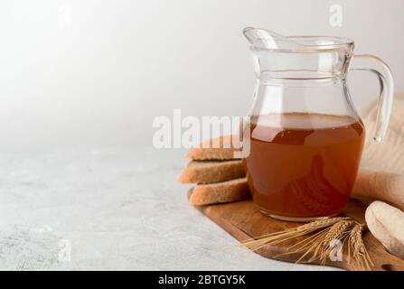 Krug mit Kvass auf weißem Hintergrund. Ein traditionelles russisches Erfrischungsgetränk mit Roggenbrot. Kopierbereich Stockfoto