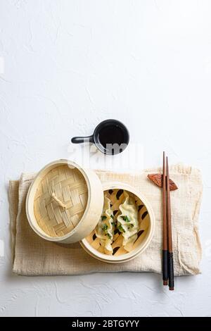 Chinesische Snacks. chinesische gedünstete Knödel. Chinesische traditionelle Küche in Holzdampfer, Knödel Snack, auf Leinen Tuch auf weiß strukturierte sto serviert Stockfoto