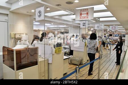 Die Käufer halten eine soziale Distanz zwischen einander, während sie am 25. Mai 2020 im Matsuya Ginza Kaufhaus in Tokio, Japan, Schlange stehen, um zu bezahlen. Quelle: AFLO/Alamy Live News Stockfoto