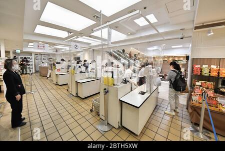 Die Käufer halten eine soziale Distanz zwischen einander, während sie am 25. Mai 2020 im Matsuya Ginza Kaufhaus in Tokio, Japan, Schlange stehen, um zu bezahlen. Quelle: AFLO/Alamy Live News Stockfoto