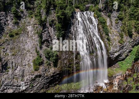 Narada Falls, im Mount Rainier National Park. Am unteren Rand der Wasserfälle hat sich ein Regenbogen gebildet Stockfoto