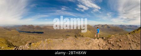 Panoramablick auf den Mann auf der Bergspitze in Schottland. Beinn Alligin, Torridon Stockfoto