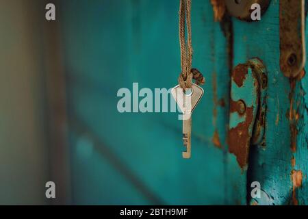 Ein Schwarm-Türschlüssel hängt an einem Seil vor einem blauen Hintergrund der Tür Stockfoto