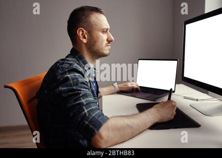 Grafikdesigner Arbeiten mit interaktivem Stift-Display, digitalem Zeichentablett und Stift auf einem Computer mit leerem Monitor Stockfoto
