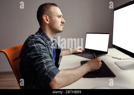 Grafikdesigner Arbeiten mit interaktivem Stift-Display, digitalem Zeichentablett und Stift auf einem Computer mit leerem Monitor Stockfoto