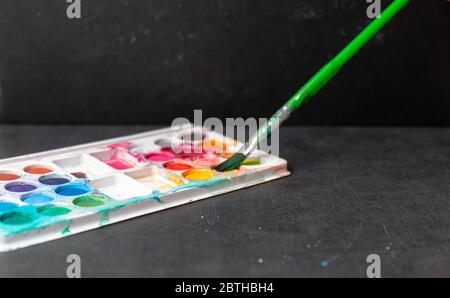Wasser und Bleistift Farben isoliert in bunten Hintergrund Stockfoto