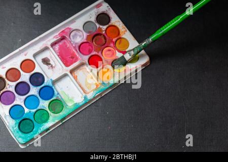 Wasser und Bleistift Farben isoliert in bunten Hintergrund Stockfoto