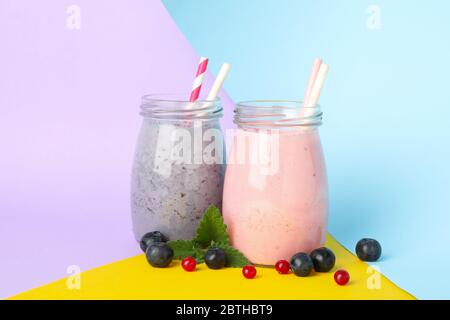 Gläser Beerenmilchshake auf zweifarbigem Hintergrund. Sommerdrink Stockfoto