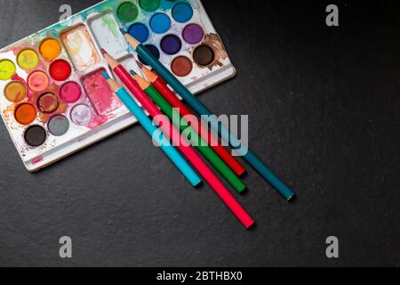 Wasser und Bleistift Farben isoliert in bunten Hintergrund Stockfoto