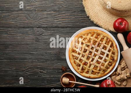 Komposition mit Apfelkuchen und Zutaten auf Holzhintergrund. Hausgemachte Speisen Stockfoto