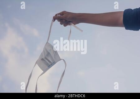 Hände halten schützende Gesichtsmaske.Anti-Verschmutzung Maske. Gesichtsmaske auf blauem Himmel Hintergrund. Stockfoto