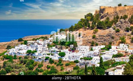 Das berühmte und historische mittelalterliche Dorf Lindos auf der griechischen Insel Rhodos mit der Akropolis im Hintergrund Stockfoto