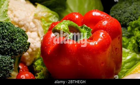 Nahaufnahme Foto von Wasser sabelt auf der roten Paprika auf dem Küchentischtisch. Hintergrund für gesunde Lebensmittel und GVO-freie Produkte.Diät Ernährung und frisch Stockfoto