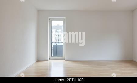 Leeres großes Zimmer mit Balkontür in der Wohnung nach Renovierung vor dem Einzug Stockfoto