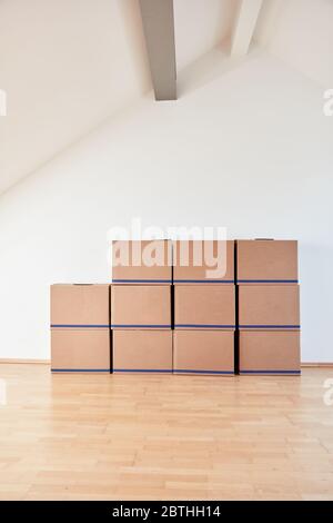 Umzugskisten an der Wand in einer hellen Wohnung oder im Büro nach dem Einzug Stockfoto