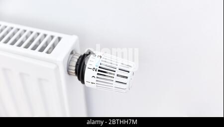 Weißer Heizkörper mit Heizkörper und einem modernen Thermostat an der Wand in einer Wohnung Stockfoto