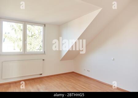 Leere helle weiße Zimmer in der obersten Etage Wohnung mit Fenster und Heizung Stockfoto