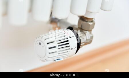 Moderner Thermostat auf Heizung beim Heizen einer Wohnung im Winter Stockfoto