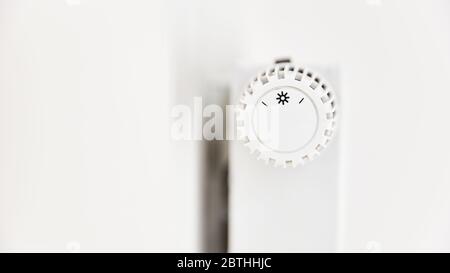 Weißer Thermostat und Temperaturregler auf Heizung mit Heizkörper Stockfoto