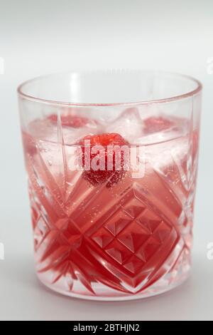 Ein Bramble in einem altmodischen Glas serviert. Diese Version des Gin-Cocktails hat eine Himbeere. Stockfoto