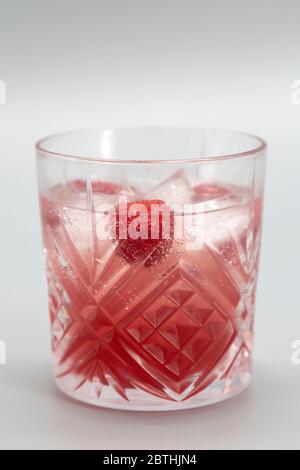 Ein Bramble in einem altmodischen Glas serviert. Diese Version des Gin-Cocktails hat eine Himbeere. Stockfoto