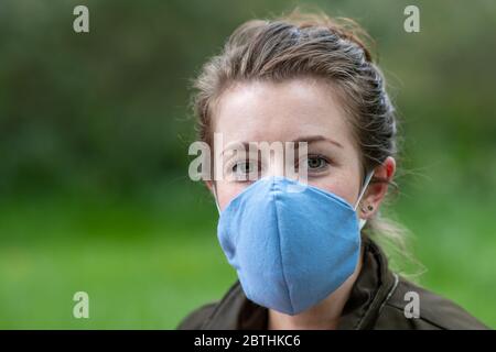 Eine junge Frau trägt eine hausgemachte Gesichtsmaske Schild, um die Ausbreitung der Covid Coronavirus Pandemie zu verhindern Stockfoto