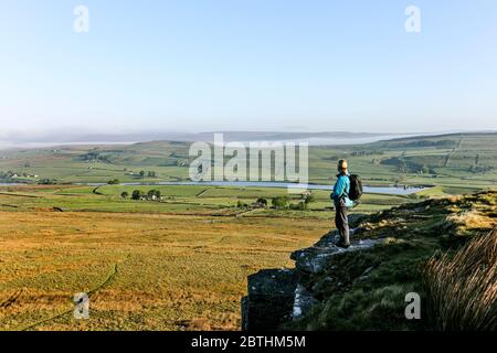 Walker Genießen Sie den Blick über den Blackton Reservoir von Goldsborough Crag auf der Bowes Loop des Pennine Way, Baldersdale, Teesdale, County Durham, Großbritannien Stockfoto